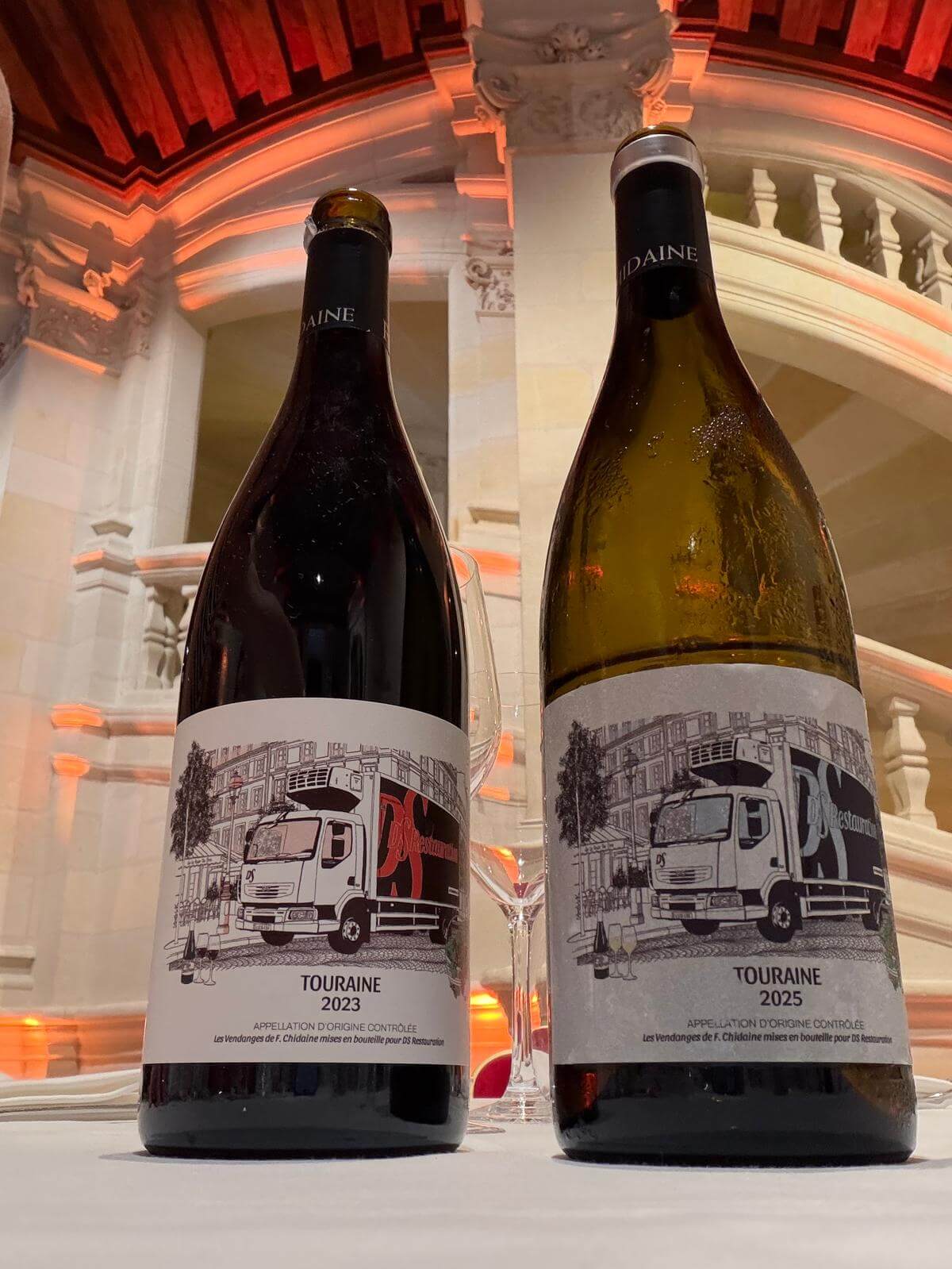 Deux étiquettes de vin sur mesure illustrées par Paper & Pen pour DS Restauration, présentées sur les bouteilles de la cuvée spéciale du séminaire au château de Chambord